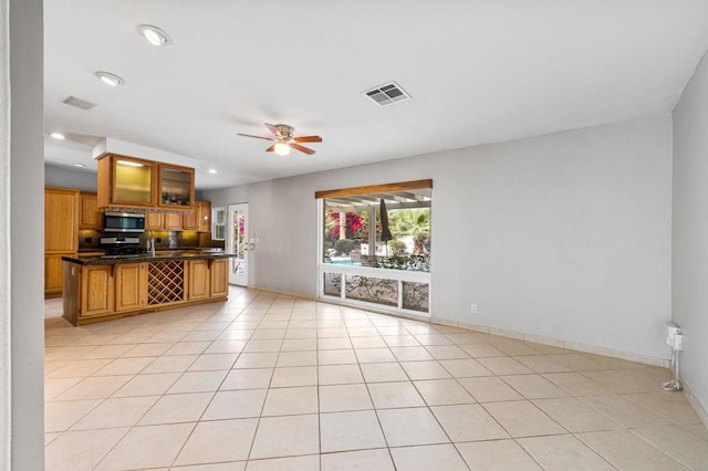 kitchen with light tile patterned flooring, a breakfast bar, ceiling fan, and appliances with stainless steel finishes