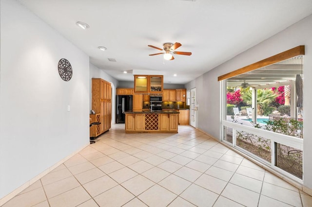 kitchen with a breakfast bar, light tile patterned floors, ceiling fan, and stainless steel appliances