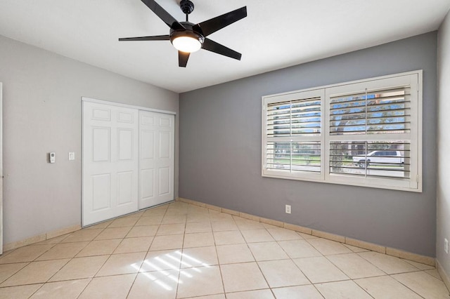 unfurnished bedroom featuring a closet, ceiling fan, and light tile patterned floors