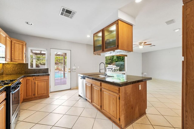 kitchen with appliances with stainless steel finishes, tasteful backsplash, light tile patterned floors, sink, and ceiling fan