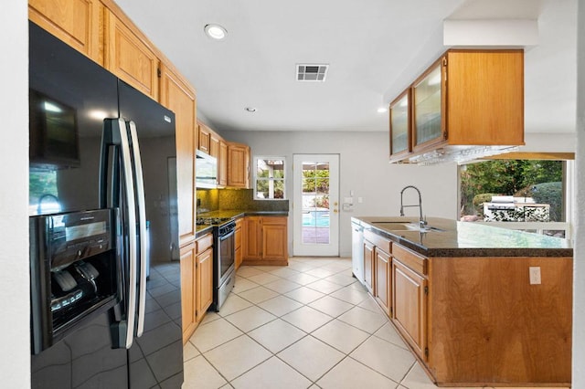 kitchen featuring sink, backsplash, light tile patterned floors, and appliances with stainless steel finishes