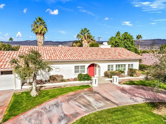 view of front of house with a mountain view, a front yard, and a garage