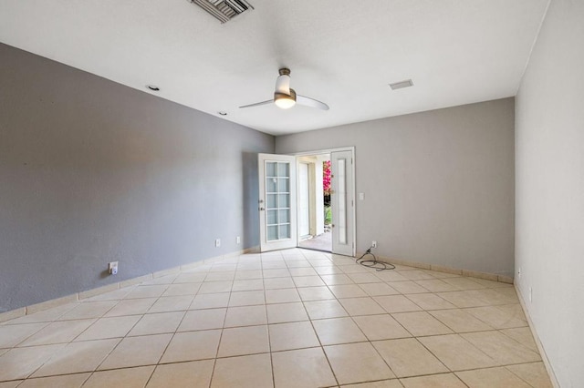 tiled empty room featuring ceiling fan