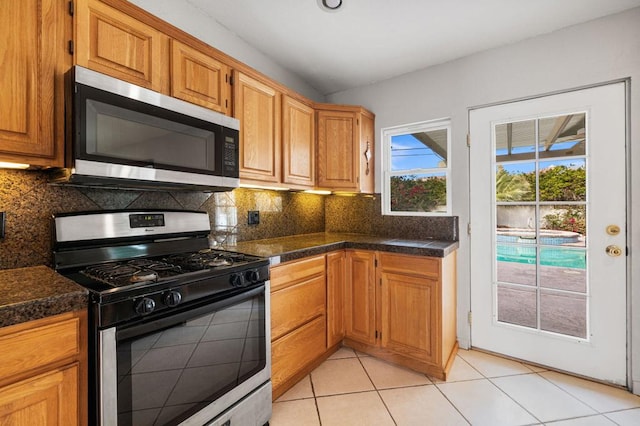 kitchen featuring light tile patterned floors, appliances with stainless steel finishes, and tasteful backsplash