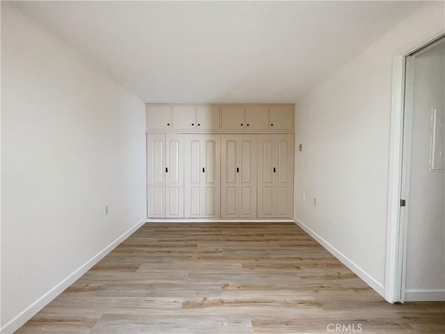 unfurnished bedroom with a closet and light hardwood / wood-style floors