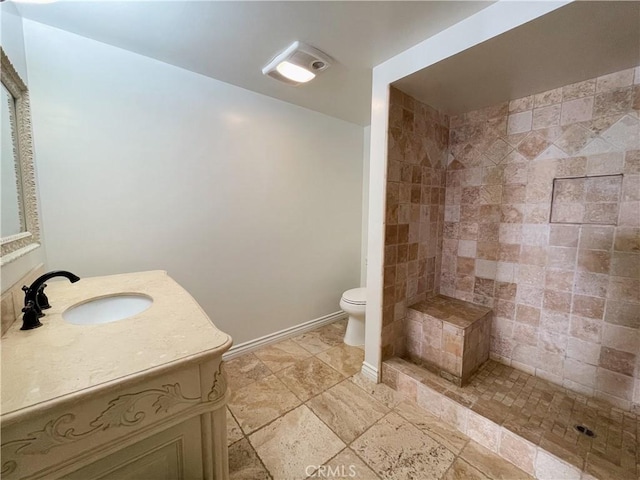 bathroom featuring vanity, toilet, and tiled shower