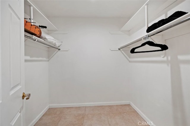 walk in closet with light tile patterned flooring