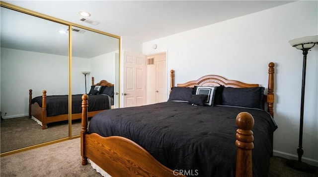 carpeted bedroom featuring baseboards, visible vents, and a closet