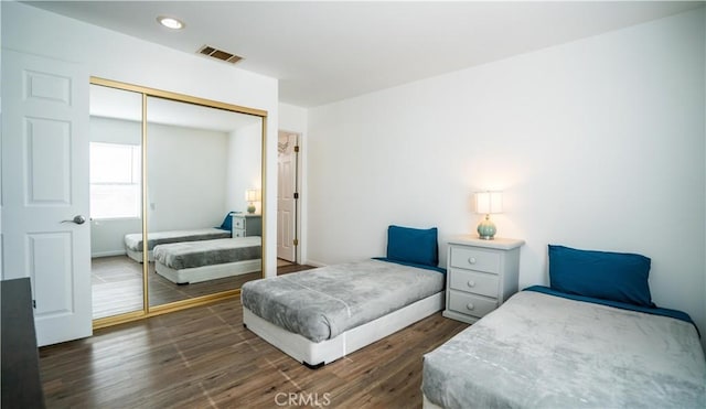 bedroom featuring dark wood-style floors, a closet, visible vents, and recessed lighting