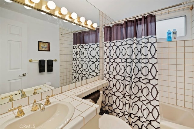 full bathroom featuring sink, shower / bathtub combination with curtain, and toilet