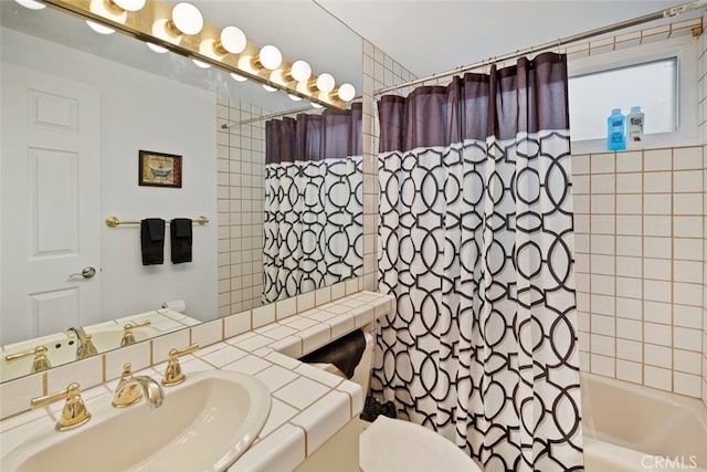 bathroom featuring shower / bath combo, a sink, and toilet