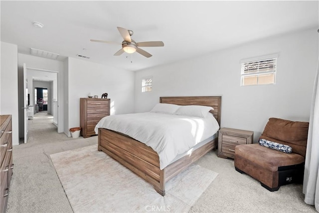 carpeted bedroom featuring multiple windows and ceiling fan