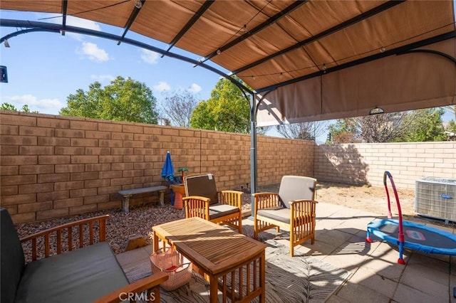 view of patio featuring central AC unit, an outdoor hangout area, and a trampoline