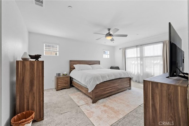 carpeted bedroom with multiple windows and ceiling fan