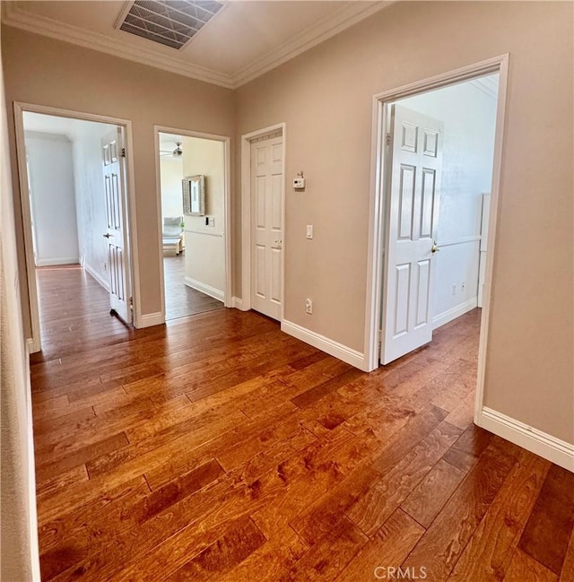 corridor featuring ornamental molding and hardwood / wood-style floors