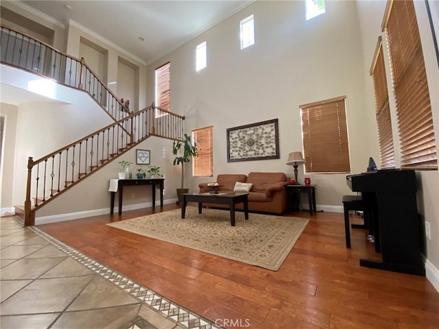 living room featuring crown molding, hardwood / wood-style floors, and a towering ceiling