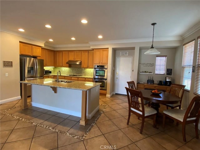 kitchen featuring decorative light fixtures, light tile patterned floors, stainless steel appliances, and an island with sink