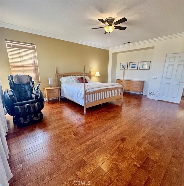 bedroom with dark hardwood / wood-style flooring, a textured ceiling, ceiling fan, and ornamental molding