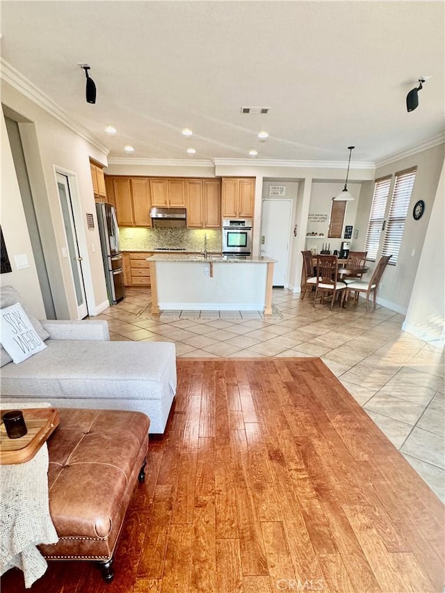 living room with sink, crown molding, and light tile patterned flooring