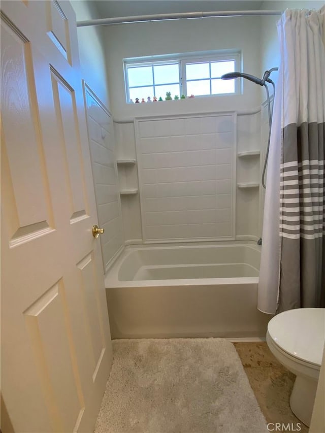 bathroom featuring toilet and shower / tub combo with curtain