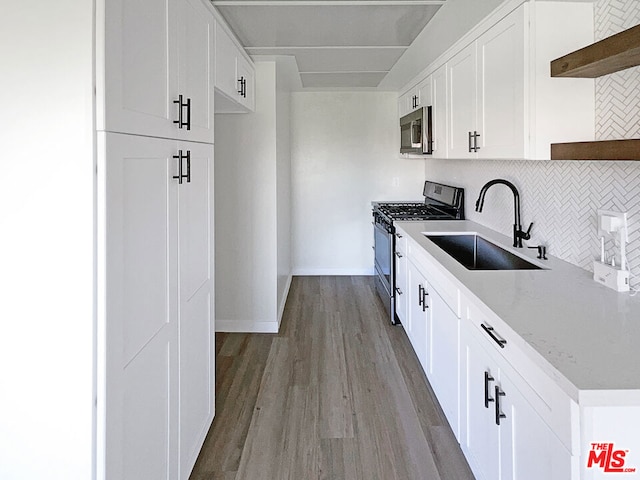 kitchen with sink, white cabinetry, appliances with stainless steel finishes, and tasteful backsplash