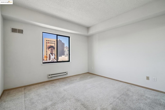 unfurnished room featuring baseboard heating, a textured ceiling, and carpet