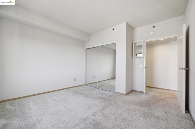 unfurnished bedroom with light colored carpet and a closet