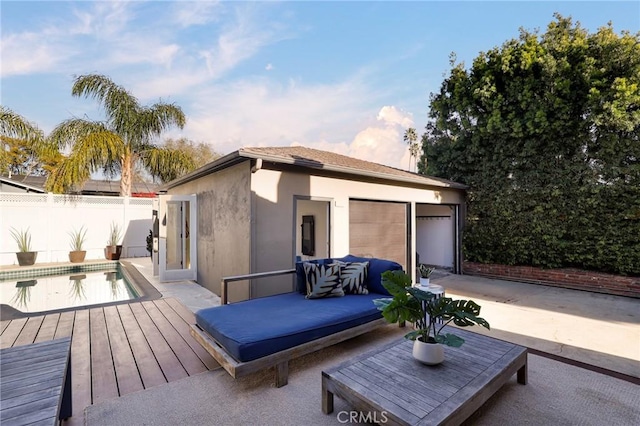 wooden deck featuring a fenced in pool, a patio, and an outbuilding