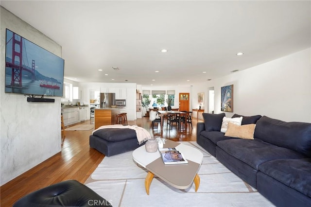 living room with sink and light hardwood / wood-style floors