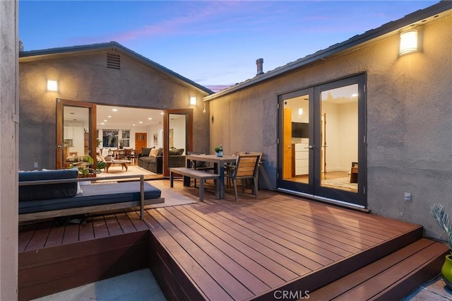 deck at dusk featuring outdoor lounge area