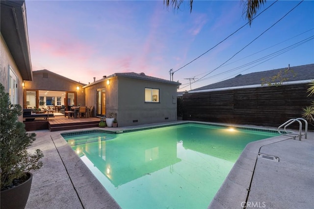 pool at dusk with a deck