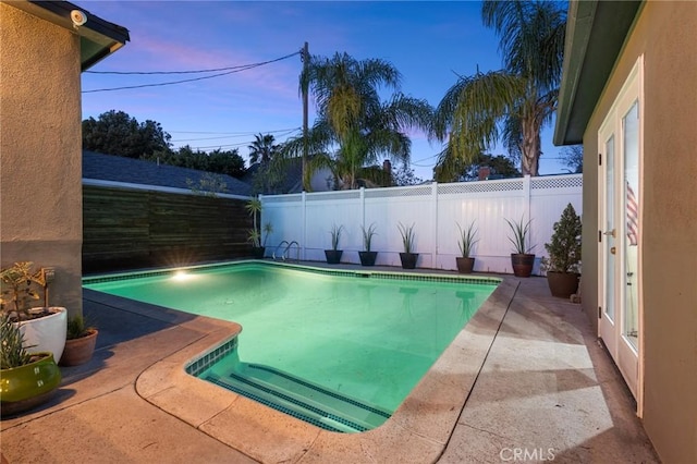 pool at dusk featuring a patio