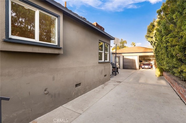 view of side of home featuring an outbuilding and a garage