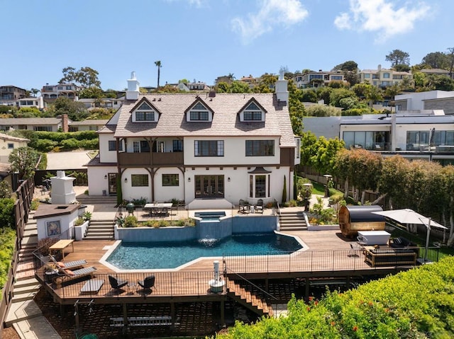 back of property featuring a pool with hot tub and a patio area