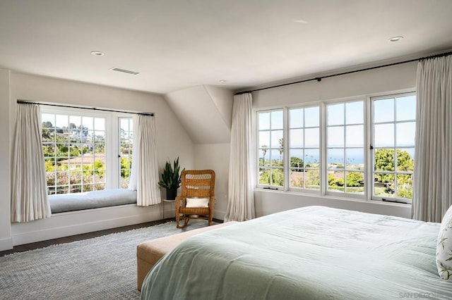 bedroom featuring multiple windows, hardwood / wood-style floors, and vaulted ceiling