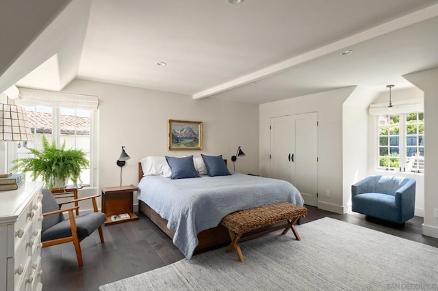 bedroom featuring a closet, beam ceiling, and dark hardwood / wood-style flooring