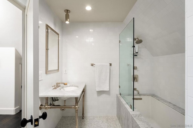 bathroom with sink, tile walls, and tiled shower / bath combo