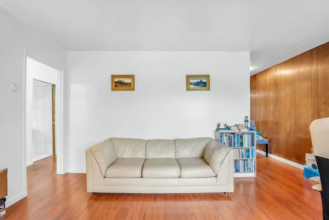 living room with wood walls and light wood-type flooring