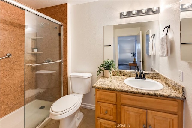 bathroom featuring toilet, tile patterned flooring, a shower with shower door, and vanity