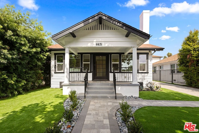 bungalow-style home featuring a porch and a front yard