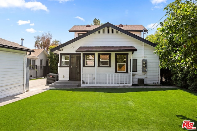 back of property featuring a lawn and cooling unit