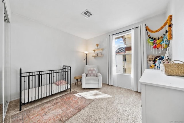 carpeted bedroom featuring a crib