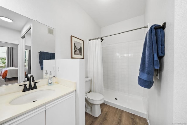 bathroom featuring vanity, hardwood / wood-style floors, a shower with curtain, and toilet