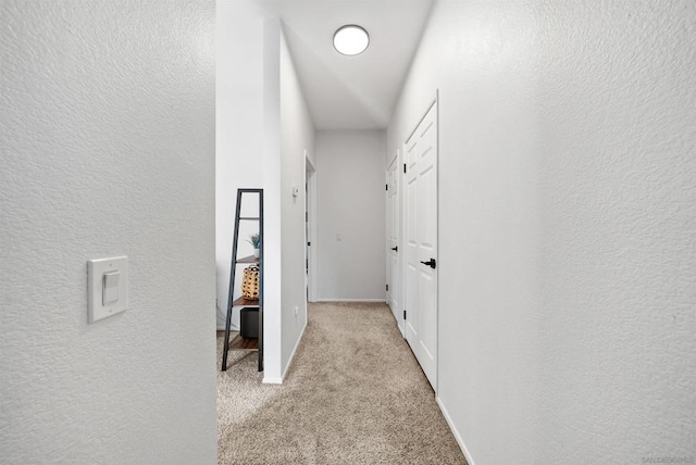 hallway featuring light colored carpet