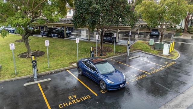 view of parking / parking lot featuring a lawn