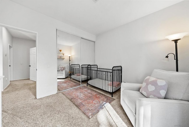 bedroom featuring a nursery area, carpet flooring, and a closet