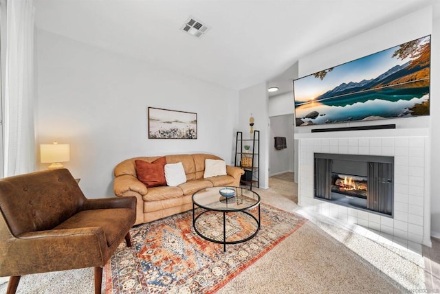 carpeted living room featuring a tiled fireplace