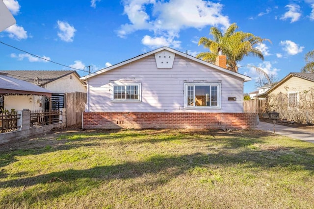 rear view of property with a lawn