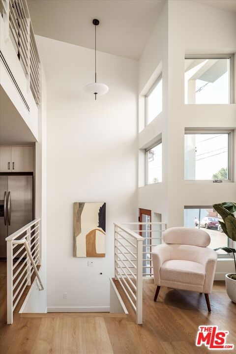 living area featuring a high ceiling and light hardwood / wood-style flooring