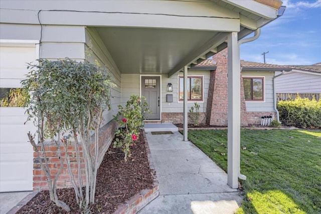 view of exterior entry with a yard